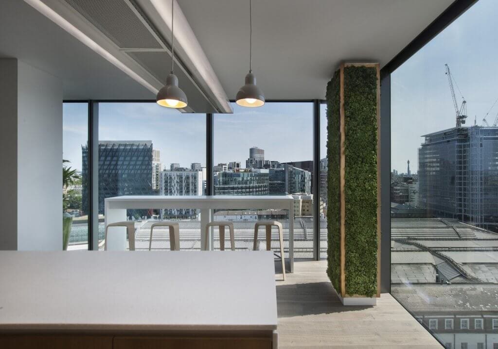 Image of the stunning biophilic design of JAB Holding Company's office, featuring natural elements such as plants, living walls, and high ceilings to create a tranquil and inviting atmosphere for employees.