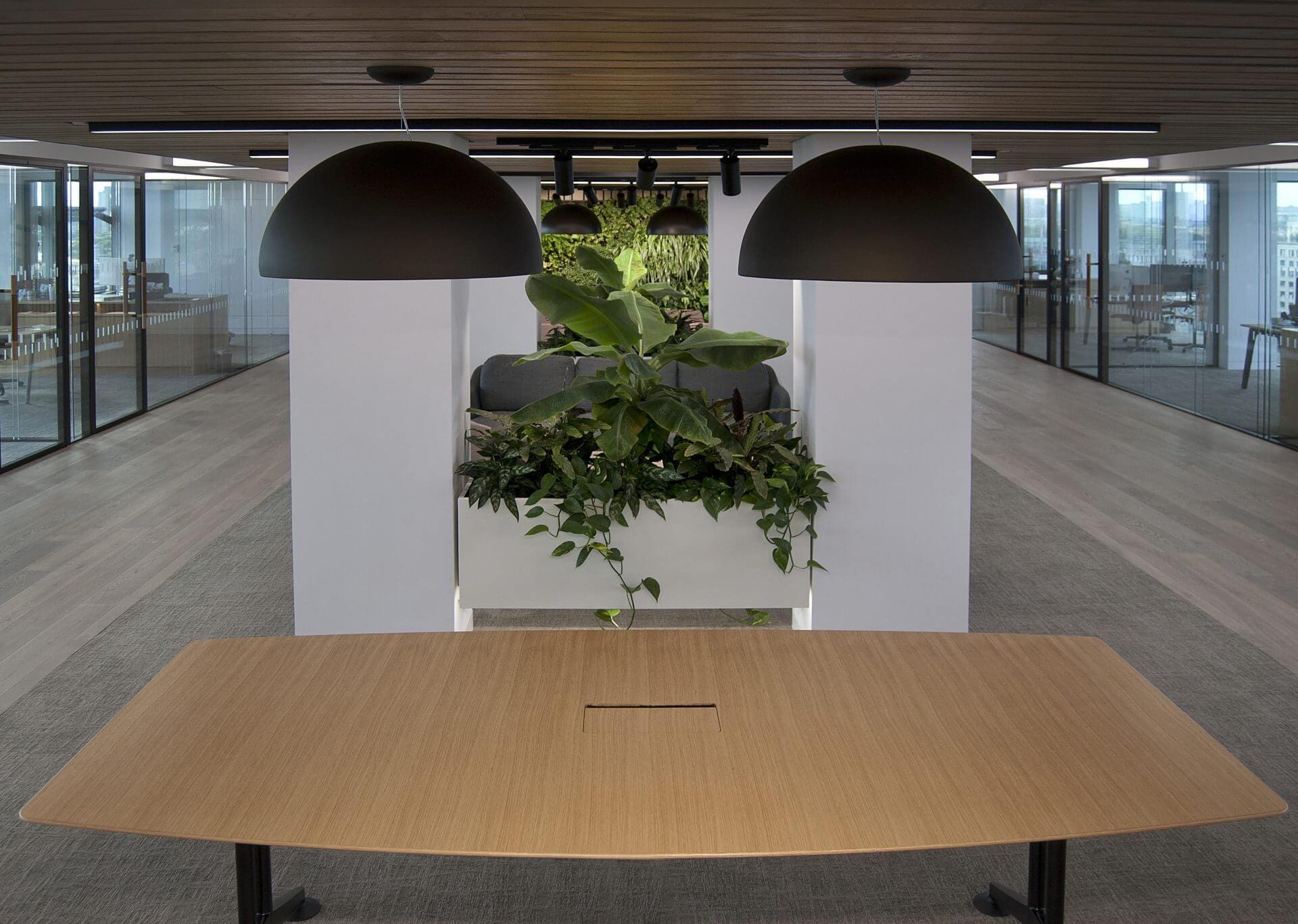 Image of the stunning biophilic design of JAB Holding Company's office, featuring natural elements such as plants, living walls, and high ceilings to create a tranquil and inviting atmosphere for employees.