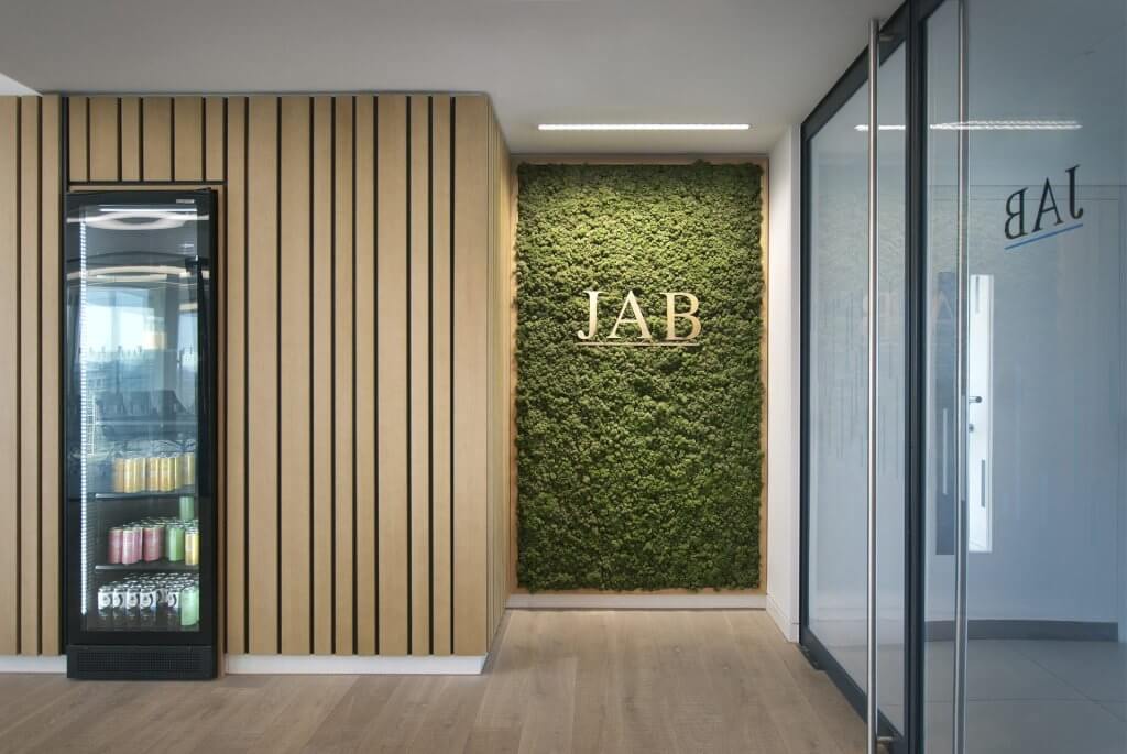 Image of the stunning biophilic design of JAB Holding Company's office, featuring natural elements such as plants, living walls, and high ceilings to create a tranquil and inviting atmosphere for employees.
