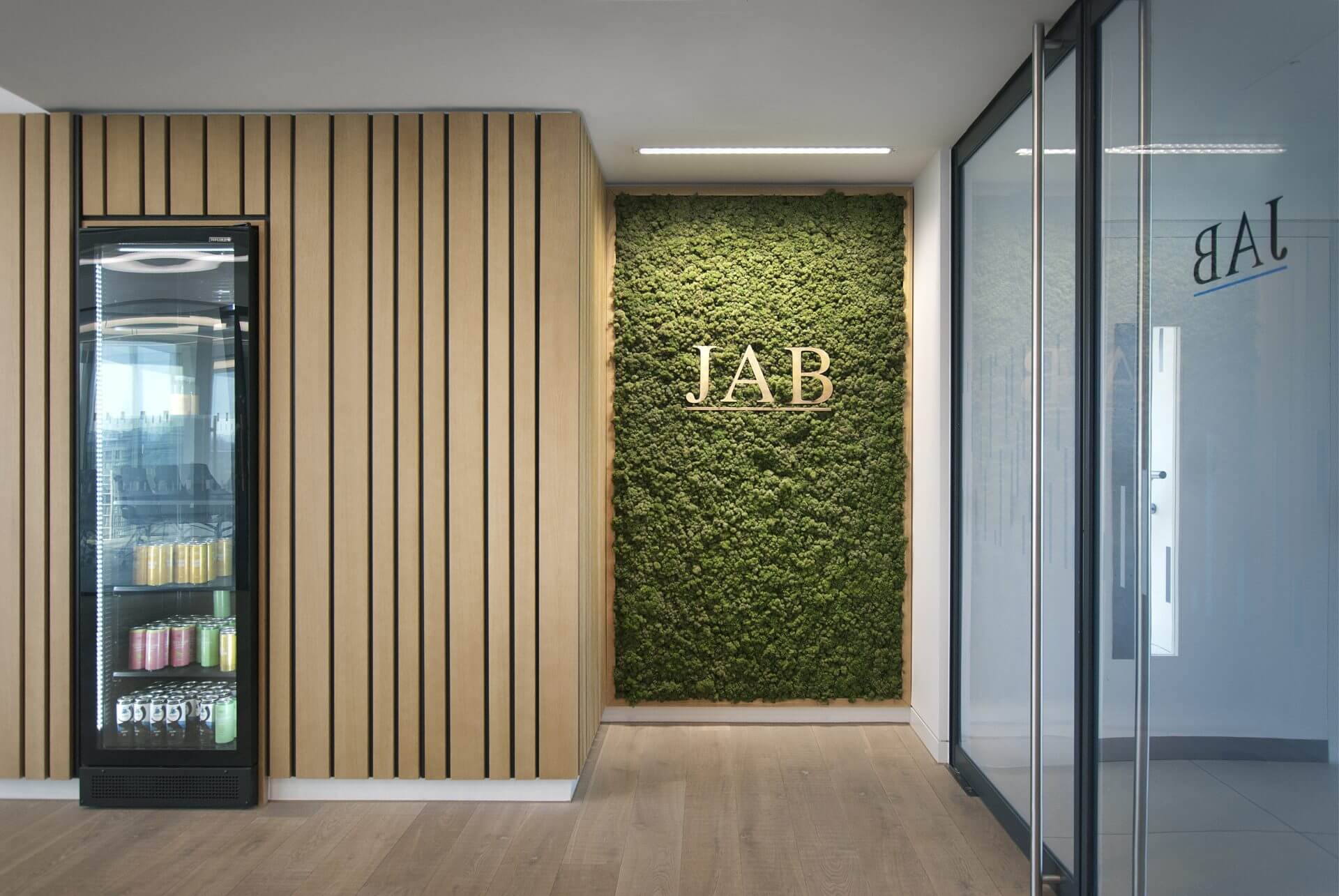 Image of the stunning biophilic design of JAB Holding Company's office, featuring natural elements such as plants, living walls, and high ceilings to create a tranquil and inviting atmosphere for employees.