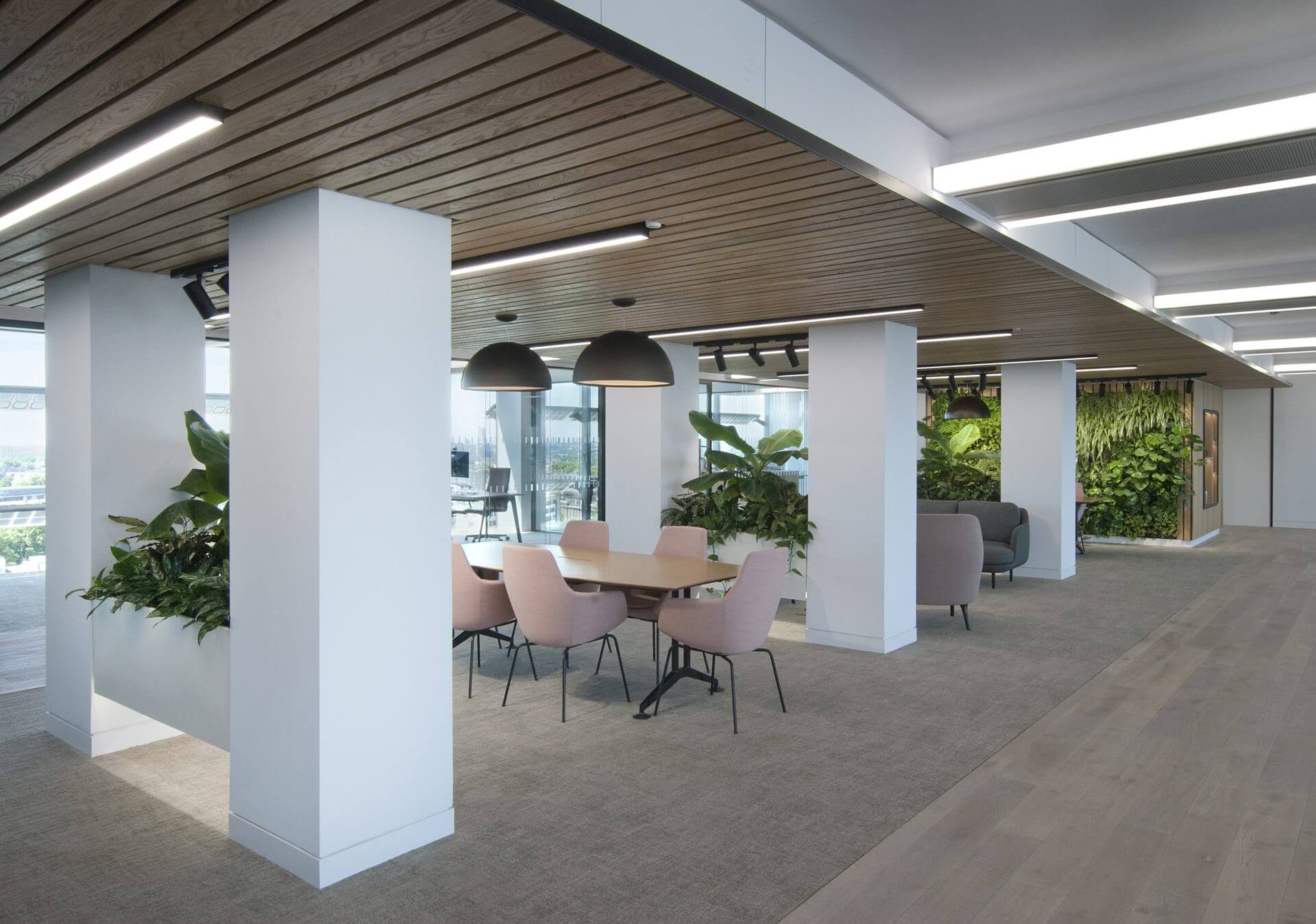Image of the stunning biophilic design of JAB Holding Company's office, featuring natural elements such as plants, living walls, and high ceilings to create a tranquil and inviting atmosphere for employees.