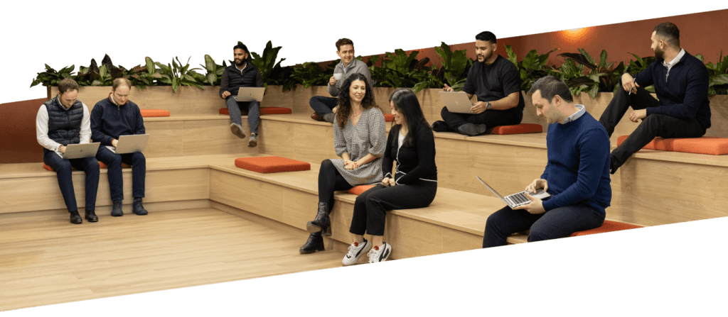 The modern JLL Birmingham office space with a group of nine staff in a casual meeting setting. Beautiful mixed planting from Verdantia